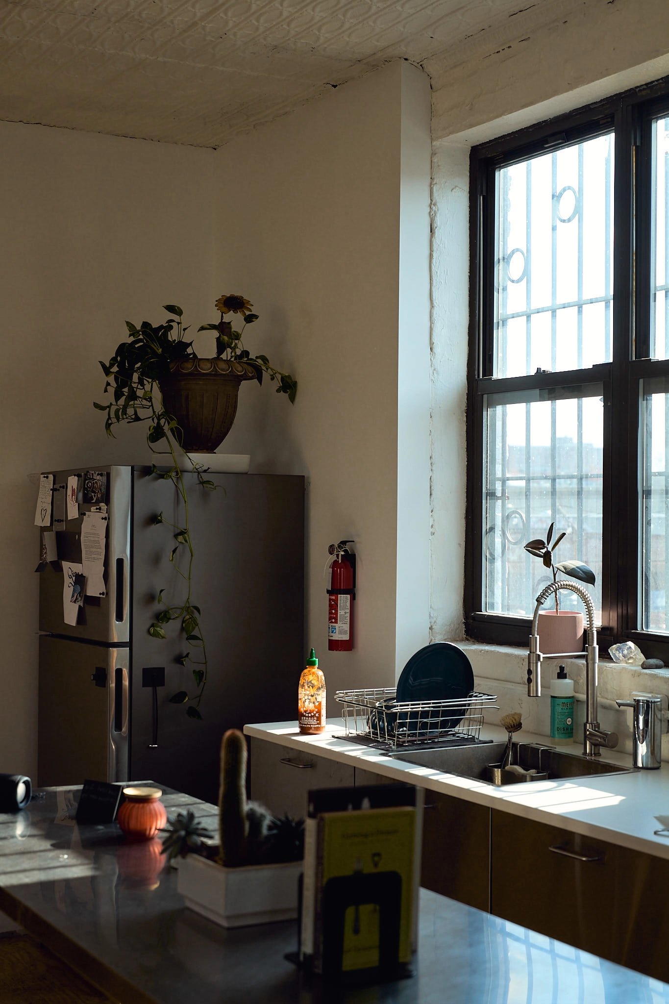 Dappled light hitting a stack of four wooden chairs.