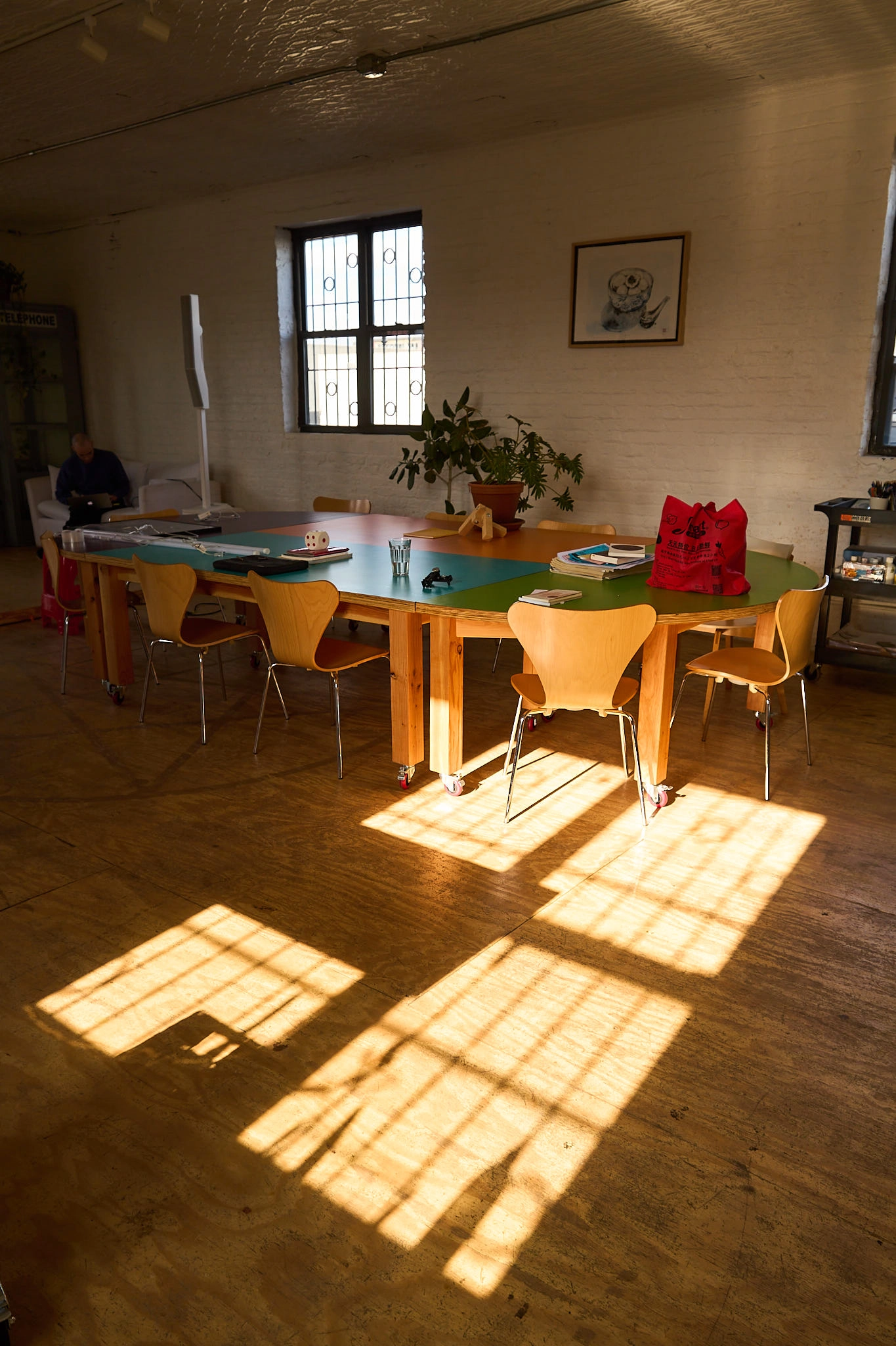 Dappled light hitting a stack of four wooden chairs.
