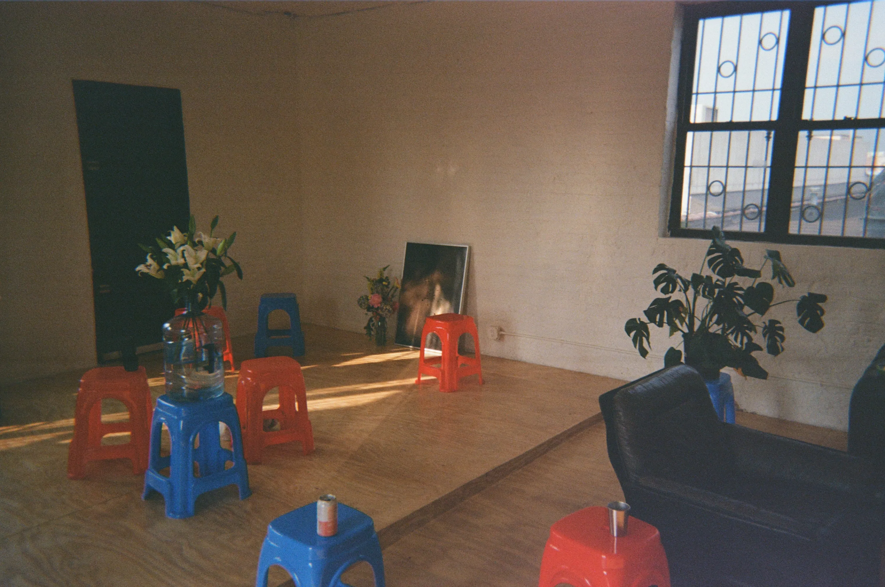 a shot from the soft opening part of telos.haus in june 2024. the photo on the floor with the bouqet by it reminds me of a funeral scene